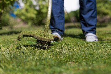 Banner. A human lawn mower cuts the grass in the backyard. Agricultural machinery for the care of the garden.