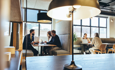 Businesspeople working in a modern co-working space - obrazy, fototapety, plakaty