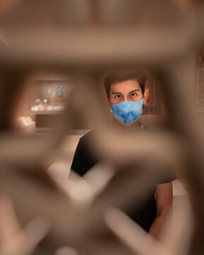 Young adult hispanic male wearing face mask covering while posing in Manhattan museum 