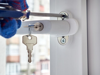 An employee installs a child-safe window handle.