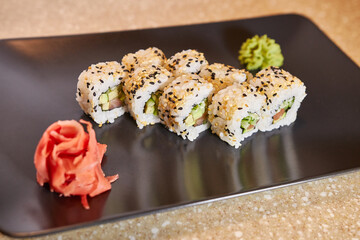 Ready sushi with red fish on a black rectangular plate. Sushi serving