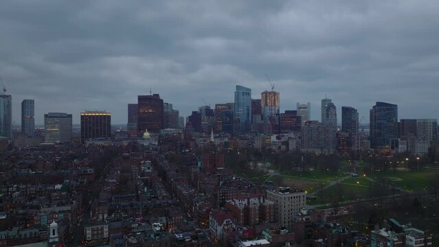 Cinematic footage of cityscape at dusk. Residential urban borough, public park and downtown skyscrapers in background. Boston, USA