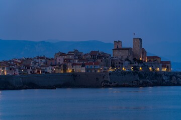 Fototapeta na wymiar Landscape view on the old coastal village and fortification of Antibes on the french riviera in France during the blue hour