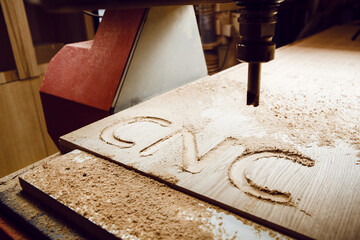 Cnc machine at carpentry workshop. Cutting wood with various router bits.