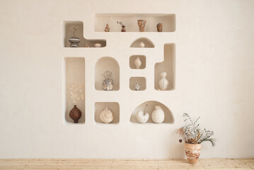 The interior is in a minimalist style with ceramic vases.