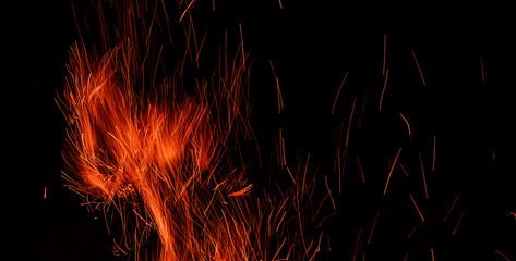 Fototapeta na wymiar Campfire flame sparks abstract picture. Beautiful fire texture isolated on black background