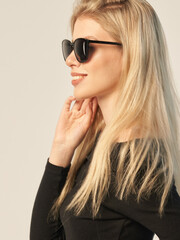 Naklejka premium fashionable portrait of a beautiful blonde in dark glasses on a white background and in a dark shirt