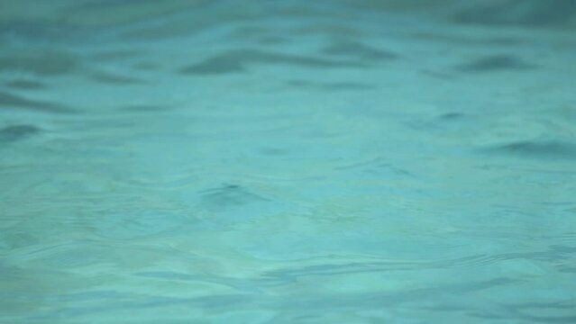 Slow motion footage of clean blue swimming pool water ripples as background