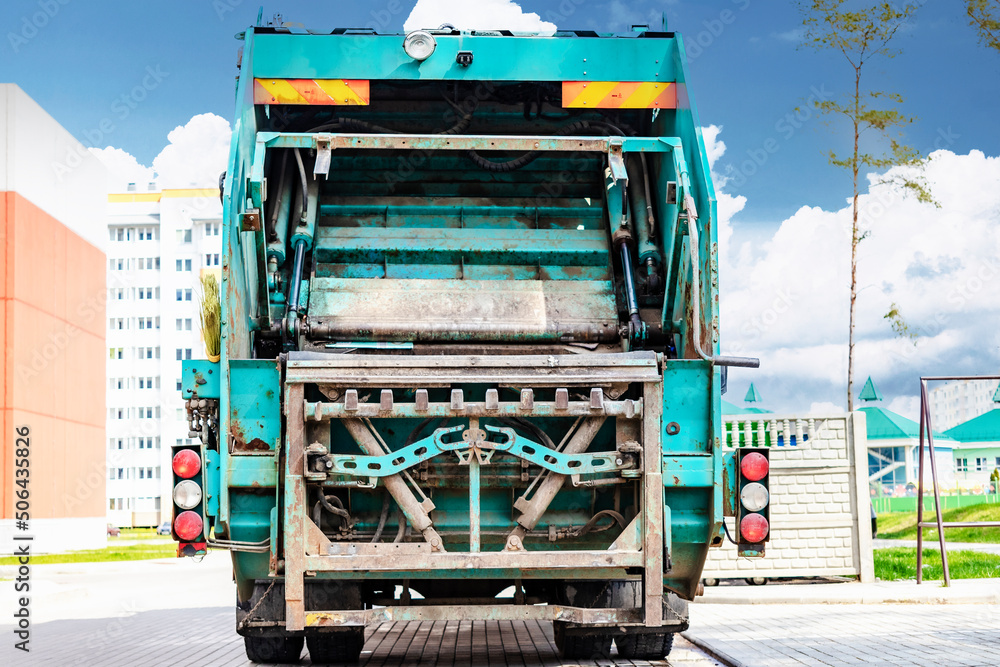 Leinwandbilder A garbage truck picks up garbage in a residential area. Loading mussar in containers into the car. Separate collection and disposal of garbage. Garbage collection vehicle.
