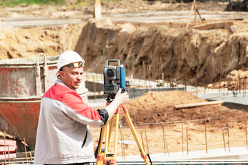 Construction of a residential area. Geodetic stakeout. Surveyor at a large construction site. A man...