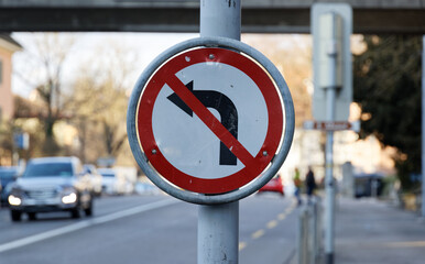 old damaged traffic sign, no left turn, black arrow on white background, red strikethrough, car...