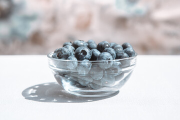 Blueberries in glass bowl on the table, healthy summer food