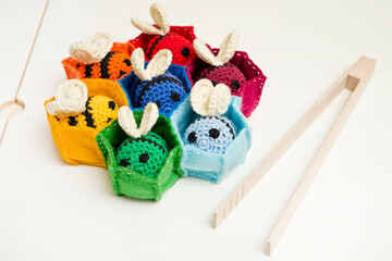 Blue and yellow crocheted bees and thread with crochet. DIY home made hand made baby rattle toy safe for toddlers.