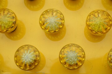 Gelbe Glaslampen auf gelber Metallfläche 