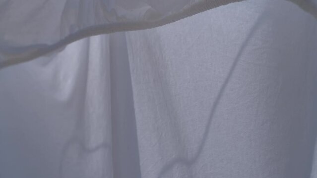 Drying white bed sheets outdoor in hot summer air and breeze