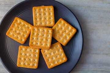 biscuits are arranged on a black ceramic plate. 