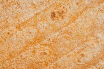 Tomato flavored wheat tortilla wraps. Spanish or Mexican circular unleavened flatbread from wheat flour. Ingredient for cooking fast food or snack. Closeup, texture background