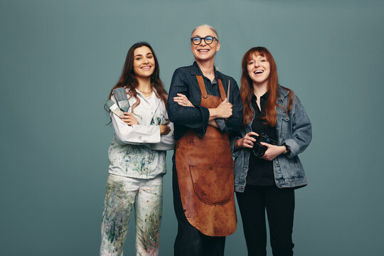 Successful women from different creative occupations smiling in a studio
