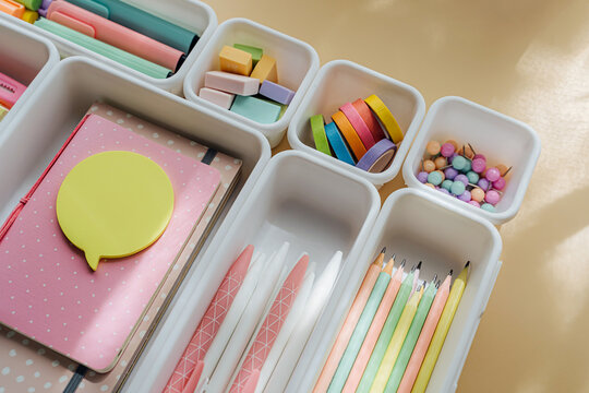 Stylish colored stationery in pastel colors is arranged in white organizers. Creative Drawer Organizing. Storage office supplies. Concept back to school.