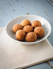 Simple plate of doughnut like brazilian sweet, bolinho de chuva, on a rustic wooden table