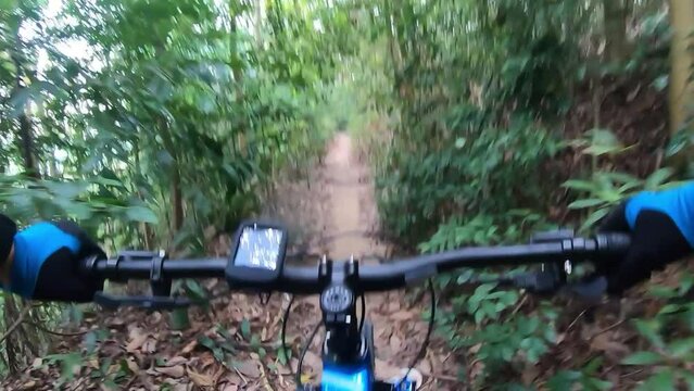 Petaling Jaya,Malaysia- February 22 2022 : Footage of a man riding a mountain biking on a single track trail also visible a Garmin bike computer. Full HD 60fps footage