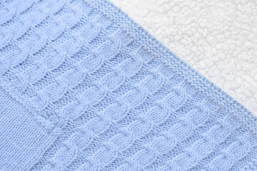 Close-up textured blue knitted fabric with white lambswool on the back, top view. Baby winter blanket for newborns