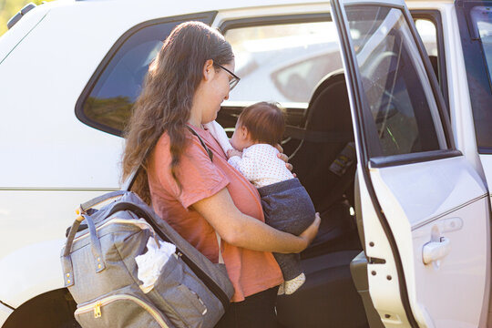 New Mum Putting Baby In Car To Go Out And About With Newborn