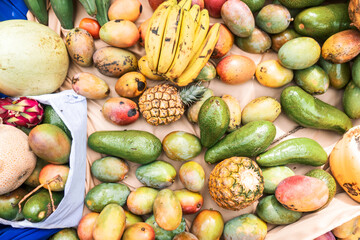 Top view of tropical fruits on a fabric background. Mangoes, avocados, pineapples, bananas and other tropical fruits. Concept of food production in Nicaragua and Latin America.