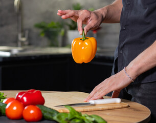 fresh juicy yellow pepper in the hands of the chef in the kitchen