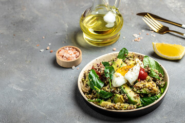 Keto diet plate quinoa, avocado, egg, tomatoes, spinach and sunflower seeds on dark background. Healthy food, ketogenic diet, diet lunch concept, Food recipe background. Close up