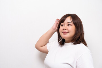 Fototapeta premium Young beautiful Asian oversize women smile with positive emotion, feeling happy and proud with her body size. Portrait shot on white background with copy space.