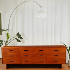 Mid-Century Modern Wooden Teak Nine drawer Dresser. Vintage bedroom furniture with houseplants and...