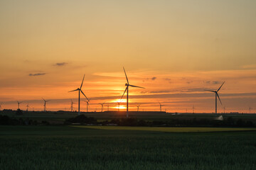 Obraz premium Wind turbines and an amazing golden sunset in Heron Belgium