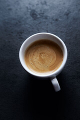 Cup of coffee on dark stone background. Close up. Copy space.