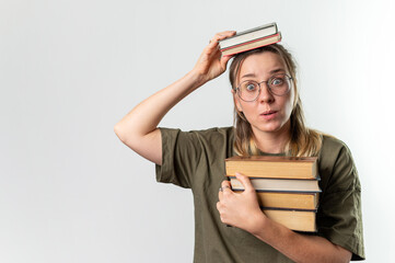 Young happy woman student holding books on her head on white background