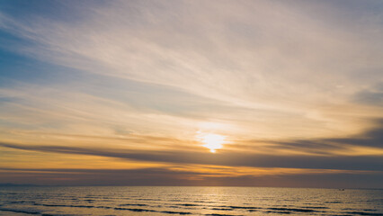 Dusk sky over sea in the evening with orange sunlight