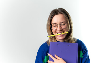 Young happy girl holding notes and a pencil in her mouth on a white background