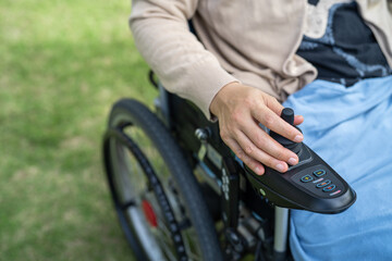 Asian lady woman patient on electric wheelchair with joystick and remote control at nursing hospital ward, healthy strong medical concept