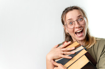 Young excited happy woman student holding books by her face on white background