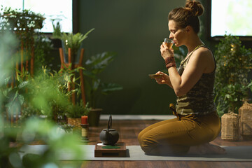 stylish woman with tea in modern green house