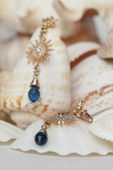 Earrings product shot. Golden vintage earrings on marine shell background. Jewelry fashion photography.	
