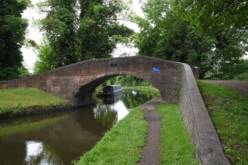 Fototapeta na wymiar the arch bridge that goes over the canal in Stourton with a canal boat on the side of the canal