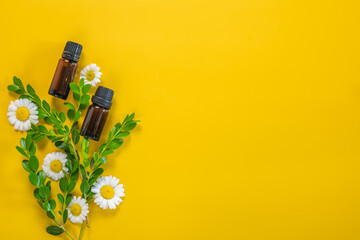 Essential oils in brown bottles on a yellow background with copy space for text