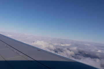 the wing of a flying aircraft against the background of clouds