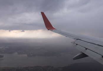 the wing of a flying aircraft against the background of clouds