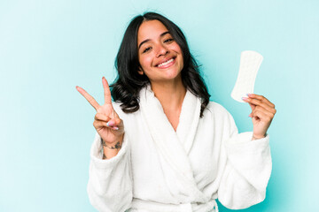 Young caucasian woman holding sanitary napkin isolated on pink background joyful and carefree...