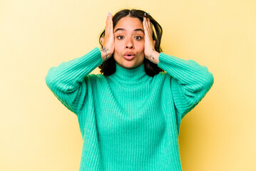 Young hispanic woman isolated on yellow background being shocked, she has remembered important...