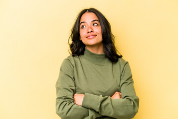 Young hispanic woman isolated on yellow background dreaming of achieving goals and purposes