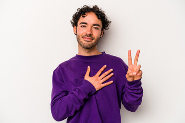 Young caucasian man isolated on white background taking an oath, putting hand on chest.
