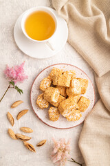 Traditional turkish delight (rahat lokum) with cup of green tea on a gray concrete background, top view, close up.